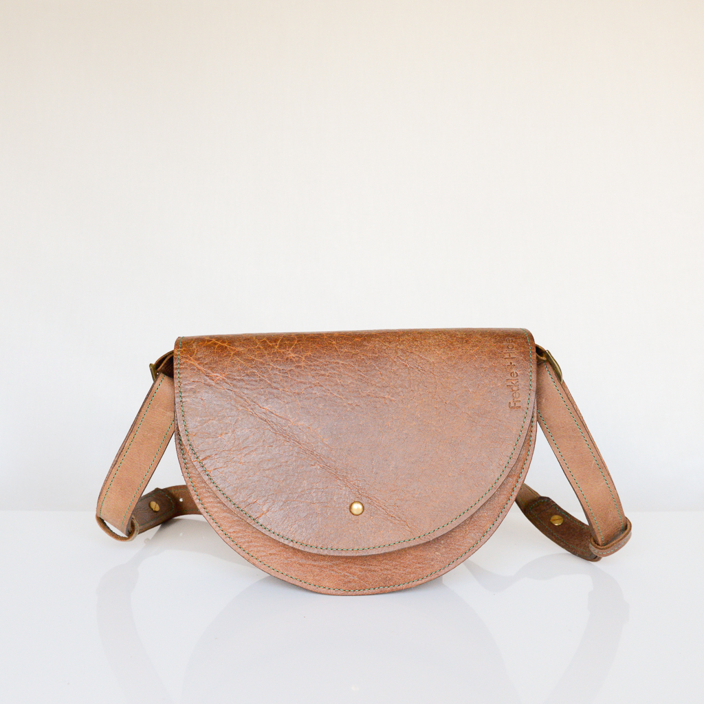 Handmade tan shoulder bag made from reclaimed and upcycled leather. Made with green contrast stitching and with adjustable shoulder strap.