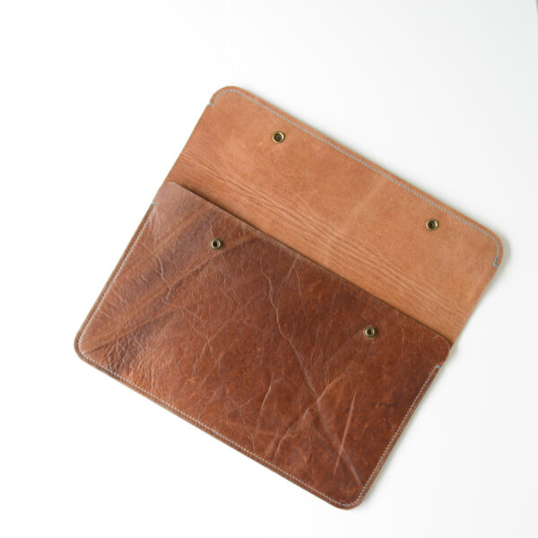 Reclaimed leather laptop case with blue stitching and brass poppers