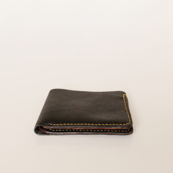 Side view of black bifold wallet made of reclaimed and upcycled leather.