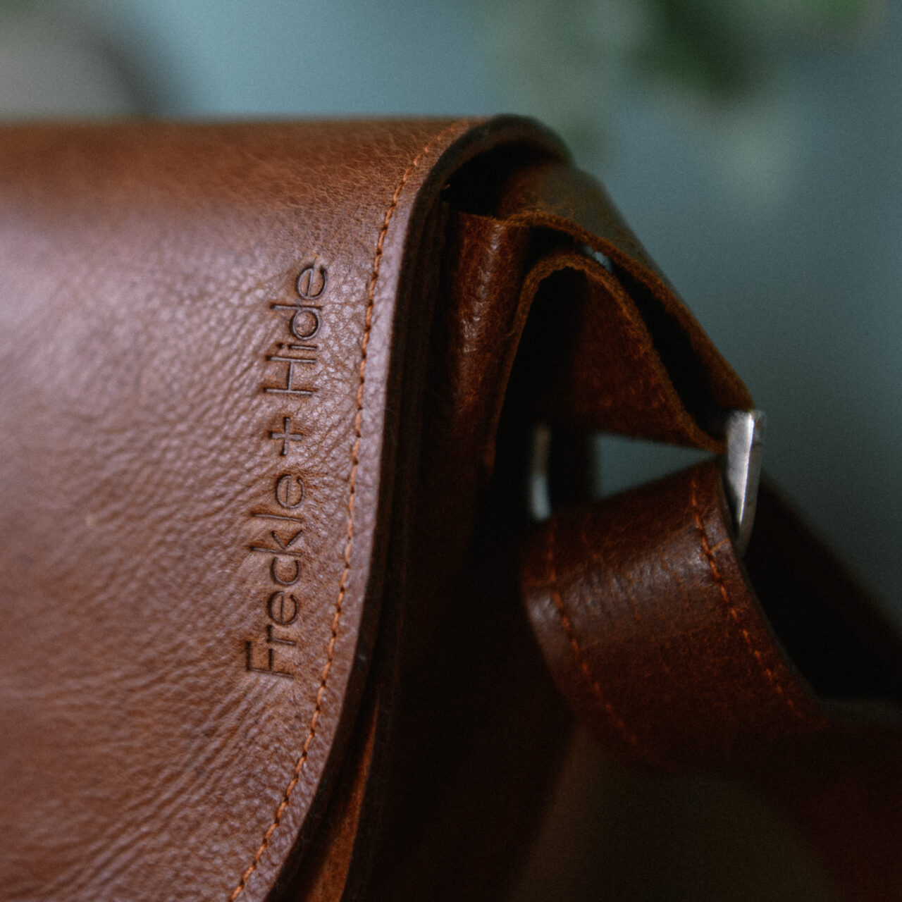 Brown leather bag with embossed logo of Freckle and Hide. Made from reclaimed leather