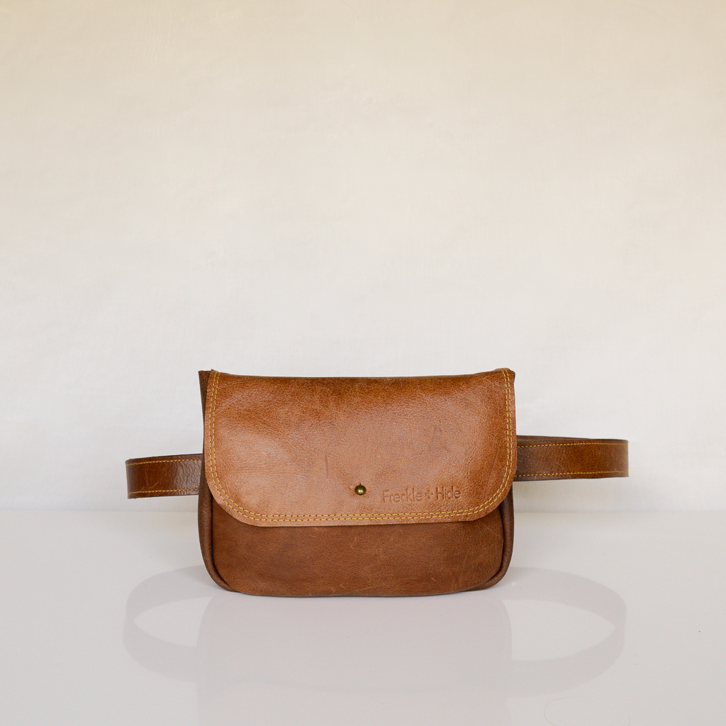 Rectangular tan leather waist bag with flap and stud closure with matching tan leather belt