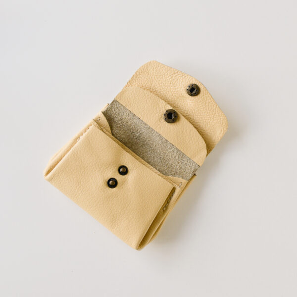 Yellow leather wallet with antique brass fastenings. Open to show the 3 internal sections