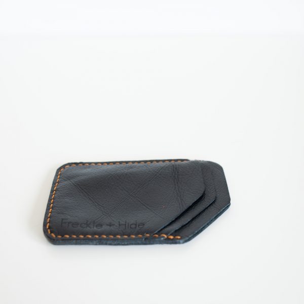 Side view of black wallet with yellow linen stitching made from upcycled leather