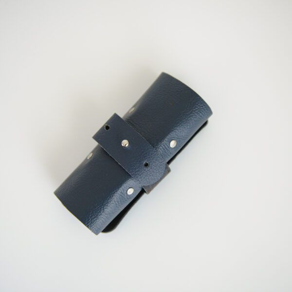 Navy blue rolled up cable tidy with silver rivets
