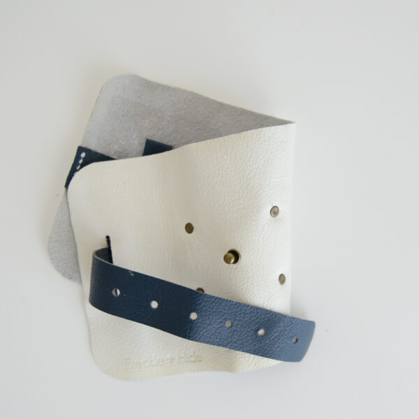 Cream and navy blue cable tidy roll with antique brass rivets